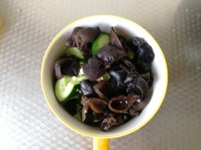 将焯好的黑木耳捞出到碗里。