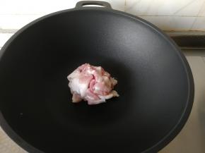 锅清洗干净，用厨房纸巾擦干。开中火，放入沥干水分的五花肉片，开始翻炒。