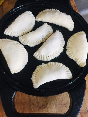 电饼铛提前预热，倒入适量的油！放入馅饼生胚！表面再刷一层油，盖上盖子！