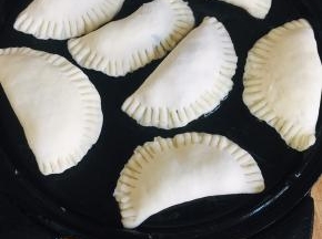 电饼铛提前预热，倒入适量的油！放入馅饼生胚！表面再刷一层油，盖上盖子！