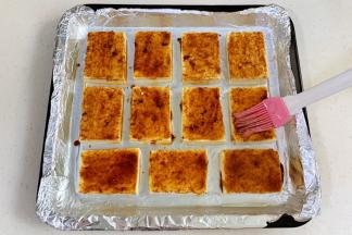 给豆腐片抹上酱汁。