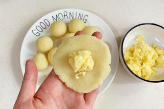 取一份土豆球按扁，包入马苏里拉芝士。