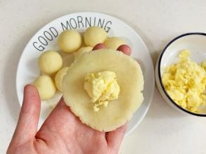 取一份土豆球按扁，包入马苏里拉芝士。