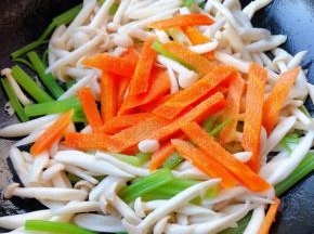 放入胡萝卜同时放入盐翻炒均匀