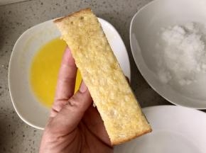 将融化的黄油抹在吐司条上。