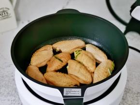 不粘锅中刷上少许食用油，再摆上鸡翅。