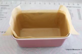 按图将油纸铺在模具里面，可以用少许的油让油纸黏住模具。