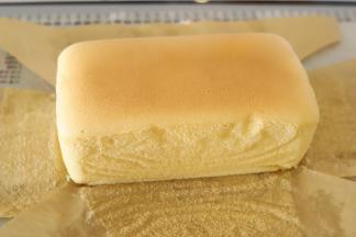 烤好的蛋糕马上出炉，脱模，撕掉油纸后放在晾架上放至凉透。