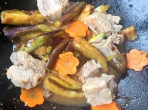 放入茄子炒出水份放入胡萝卜炒至断生放入排骨炒匀