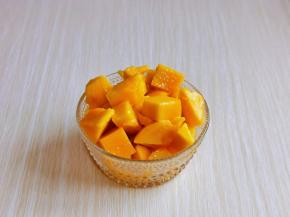 利用这时间准备其它食材，芒果洗干净去核，将果肉切下。