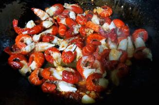 放入小龙虾尾同时放入糖和料酒大火快速翻炒