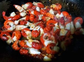 放入小龙虾尾同时放入糖和料酒大火快速翻炒