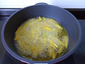 油温四成热下南瓜条一根一根油炸。