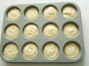 然后12连模准备好，裱花袋剪口挤入12连模中。