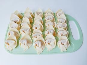 取一张馄饨皮放入馅料，包成元宝状。