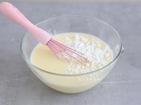 倒入牛奶，搅拌均匀，再把40克的玉米淀粉倒入碗里，用打蛋器搅拌均匀至无颗粒状。