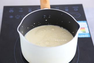 取一个过滤网，把牛奶液过滤到不粘锅里面，小火开始煮，不断的搅拌。