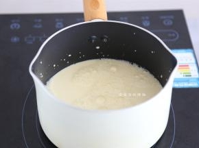 取一个过滤网，把牛奶液过滤到不粘锅里面，小火开始煮，不断的搅拌。