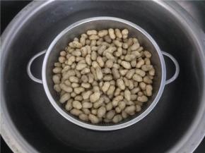 花生煮好后，放一个洗菜篮在盆里，将花生倒入，将水滤掉。