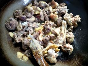 鸭肉炸得微焦，丢几块姜片，翻炒几下。