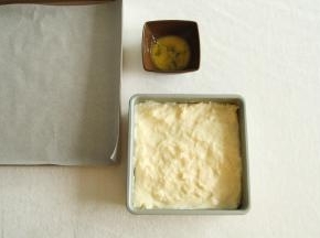 将煮好的奶糊倒入方形模具中，抹平，盖上保鲜膜，常温冷凉后放入冰箱冷藏3小时。冷藏好准备好垫有油纸的烤盘，还有刷表面的全蛋液。此时可以预热烤箱，上下200度。