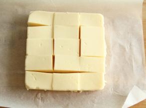 将牛奶块倒扣在案板上。横竖切开成长方形！