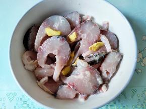 草鱼去鳞和内脏，清洗干净，头和尾另外烧菜吃，鱼身切四五毫米的块，加入2汤匙料酒，半勺盐，2勺淀粉，几片姜，抓匀一下，至少腌渍10分钟。如果能切鱼片，尽量切鱼片吧，那样更好吃。