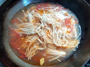 鱼肉全变白后，下金针菇煮一分钟。