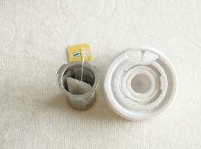 将茶包放入滤网中。卡槽卡在盖子上。