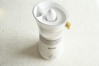 然后将椰汁、纯牛奶、细砂糖倒入小蛮腰奶茶机中。放好卡上滤网的盖子。