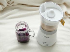 将煮好的紫薯泥舀入杯子中，四周杯壁也可以用勺子划上紫薯泥。浓稠的紫薯泥可以挂壁的！此时奶茶也已煮好。