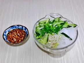 大蒜切碎放入碟中，加入生抽，盐，醋，搅拌均匀，小葱去皮洗干净切段，把豆芽，小葱，凉皮放入玻璃碗中。