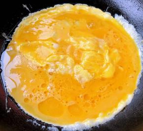 锅中倒入底油加热倒入蛋液炒至鸡蛋八成熟