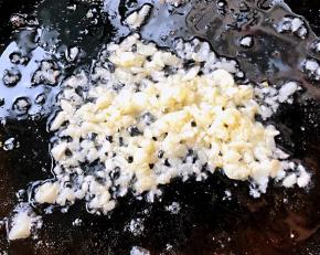 另起锅倒入底油加热放入蒜粒爆香