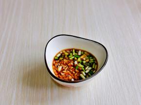 小葱与大蒜去皮切碎，放小碗中，加入生抽，米醋，油辣子。