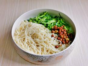 煮熟的面淋干水分，黄瓜丝，花生米放在大碗中。