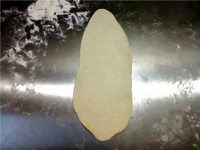 取一份面团擀成牛舌状。因为室温高，很快就在发酵，所以没有松驰，直接擀开。