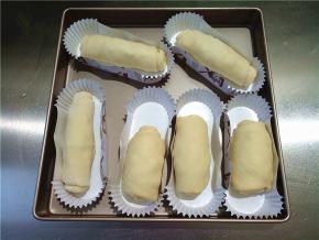 将做好的面包放在纸托中。前面三个擀的窄做的比较短胖，后面就擀得宽了一点，做瘦长一些。