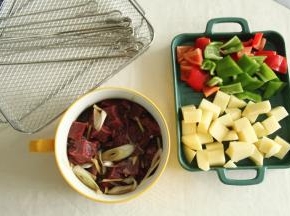 将腌制好的牛肉块取出（天热可以冷藏腌制），青红椒去柄去籽切块。土豆去皮切块（最好焯一下水，更容易烤熟）。可以用烤钎也可以用竹签。