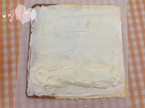 蛋糕卷的正面朝上，抹上淡奶油。