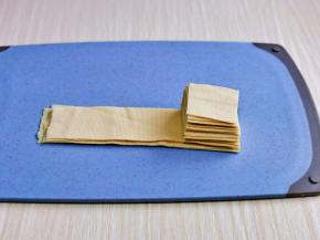 再把豆干卷打开，一片一片叠加起来，切小块。