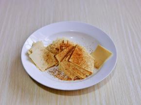 豆皮块放入盘中，撒上孜然粉，抓拌均匀。