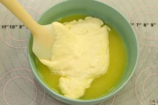 取一小勺蛋糕糊加入到黄油和柠檬汁混合物内拌匀。