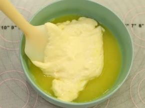 取一小勺蛋糕糊加入到黄油和柠檬汁混合物内拌匀。