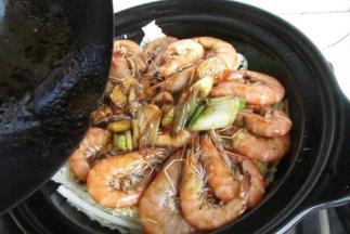 7.把虾摆到白菜上，把汤汁一起倒入，盖上盖子，开小火慢炖，白菜在这个过程中会出水，所以不用额外加水，干锅的魅力所在，熟透即可