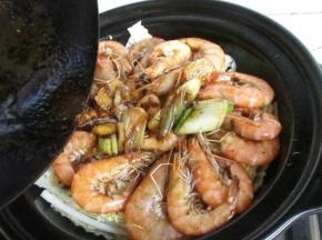 7.把虾摆到白菜上，把汤汁一起倒入，盖上盖子，开小火慢炖，白菜在这个过程中会出水，所以不用额外加水，干锅的魅力所在，熟透即可