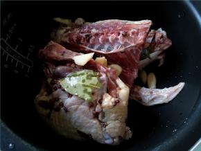 第二天，将鸭子连同腌料都倒入电饭煲中，再加几片姜和2汤匙料酒。