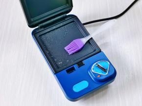 首先我们把三明治机器的烤盘上刷少许食用油，