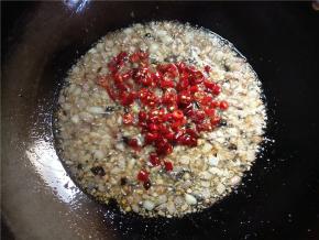 下辣椒，拌匀，炸两三分钟，小米椒变得油亮的。