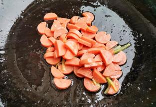 炒锅热油，爆香姜蒜，加入火腿煎一下，